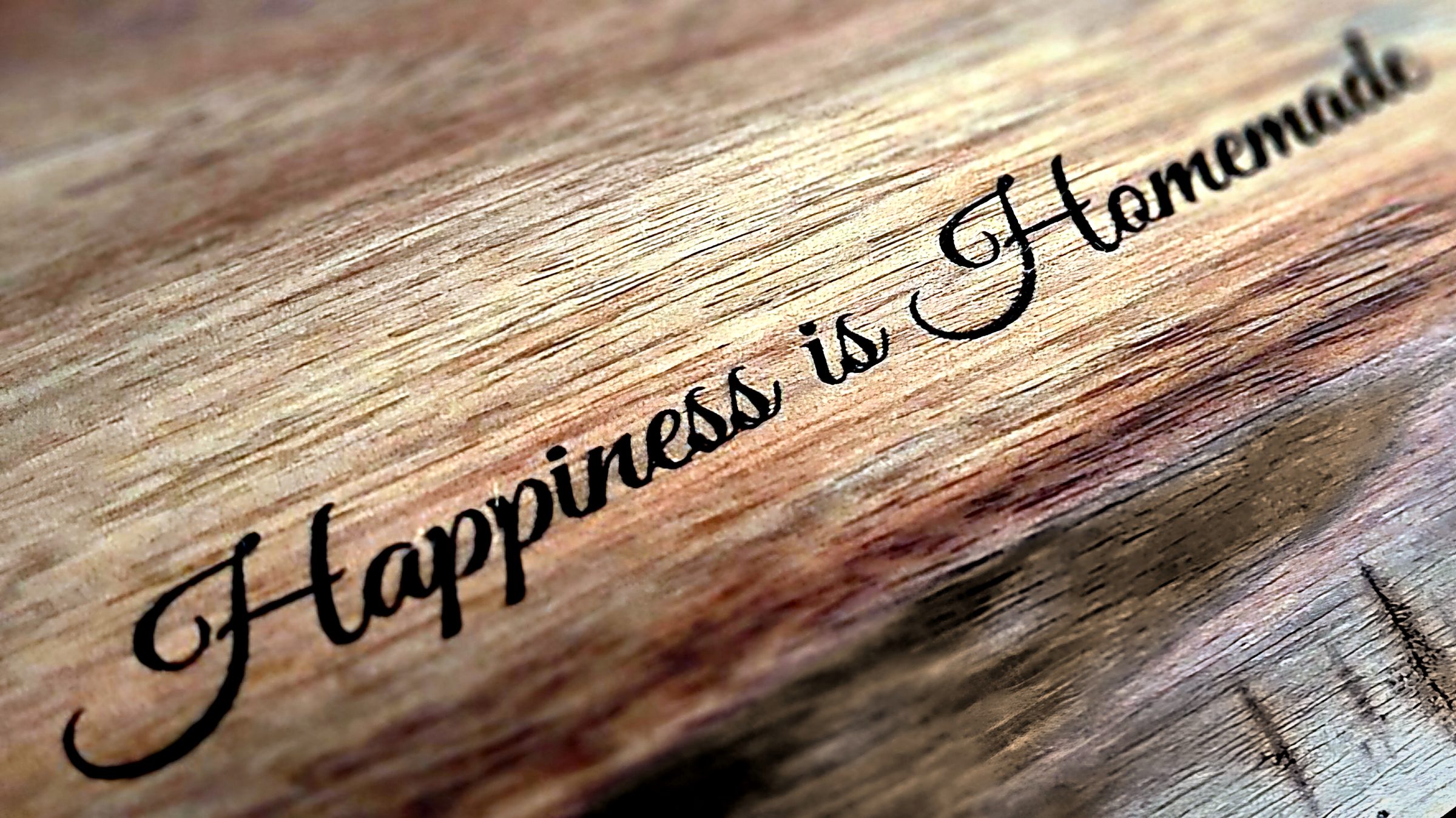 “Happiness is Homemade” laser-engraved in script on warm walnut wood